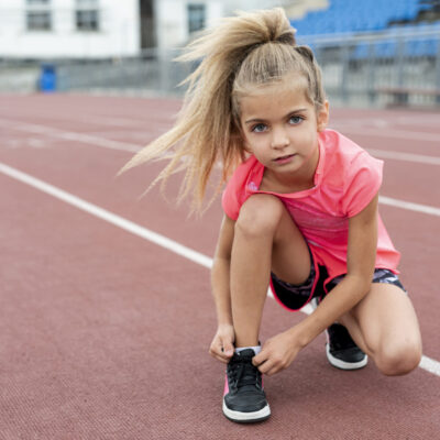 front-view-girl-tying-her-shoelaces front-view-girl-tying-her-shoelaces